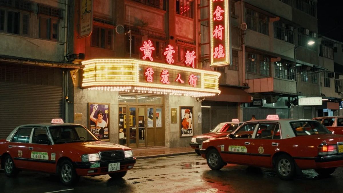 Vintage 1960s-70s Hong Kong cinema street at night with a glowing marquee and red taxis parked outside