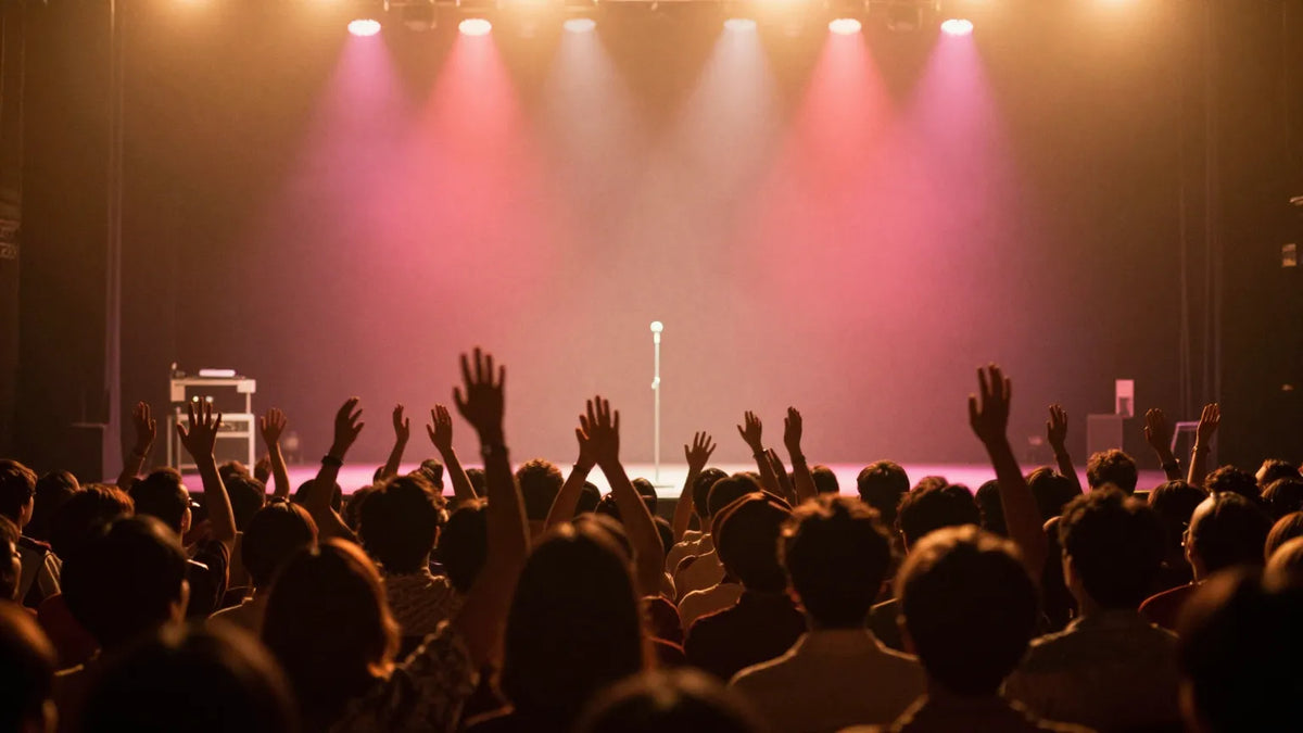 Vintage 1980s Hong Kong concert stage viewed from a packed auditorium with warm amber lights and raised hands