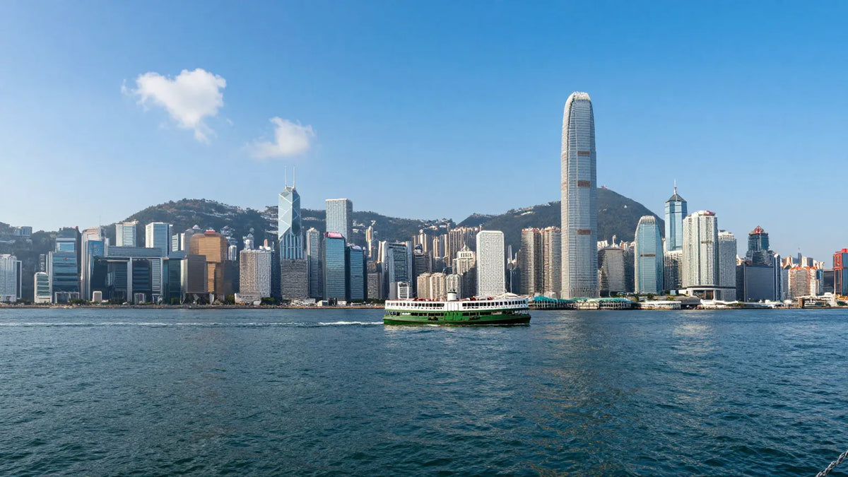 Hong Kong skyline over Victoria Harbour on a crisp autumn day with the green Star Ferry crossing the water