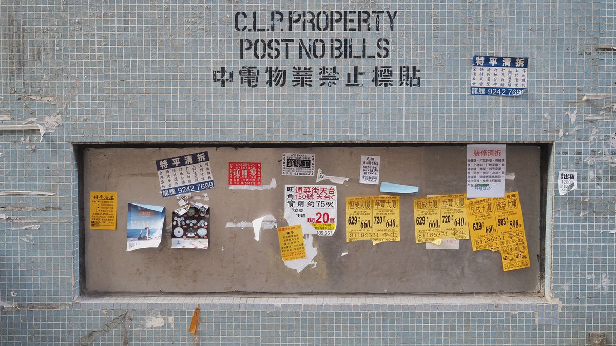 Hong Kong city wall covered in multilingual street posters capturing the texture of Hong Kong cinema's urban setting