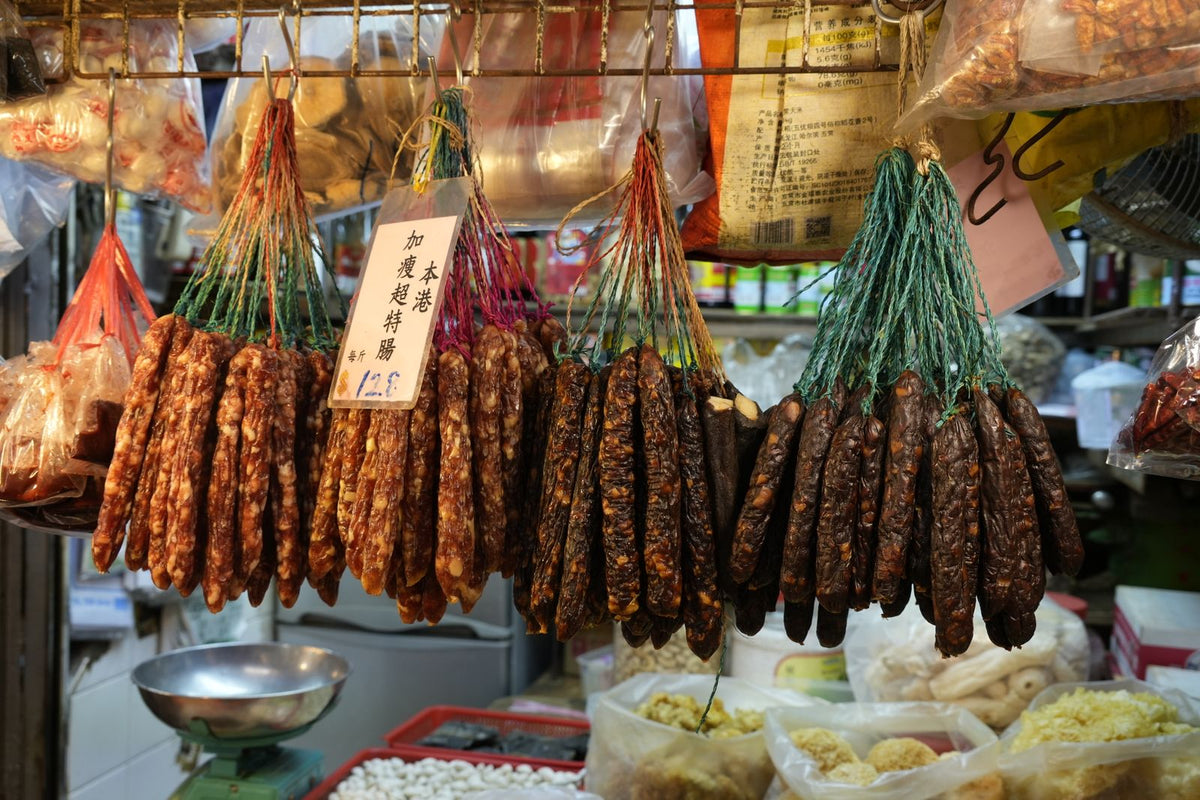 Assorted dried Cantonese lap mei sausages hanging in a Hong Kong market stall