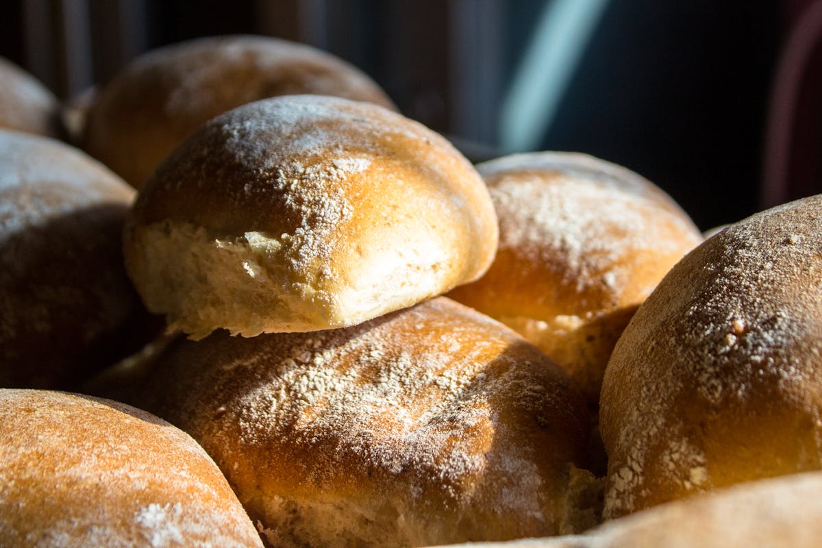 Freshly baked golden bread rolls in a sunlit bakery