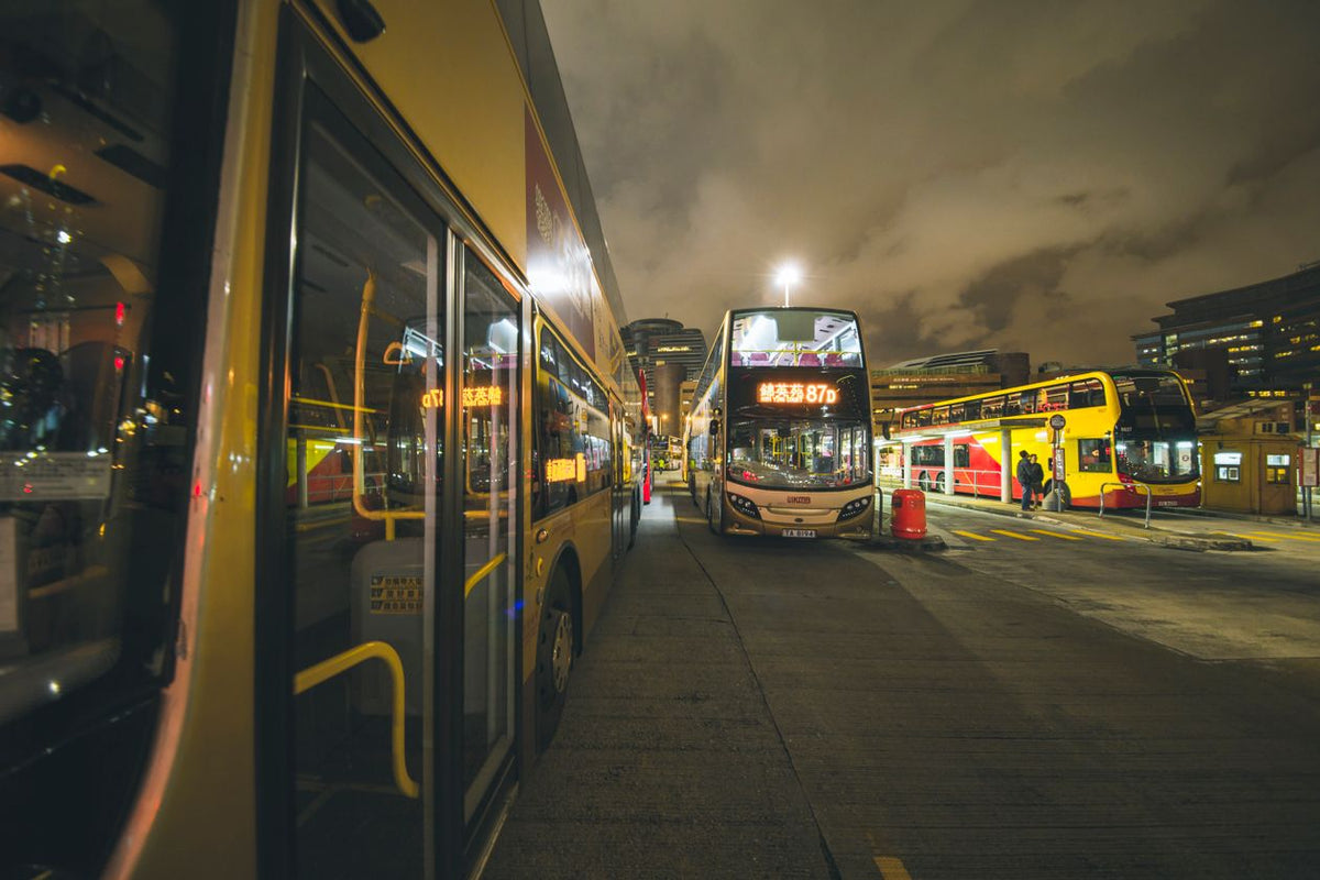 City buses at a nighttime bus stop in Kowloon, Hong Kong
