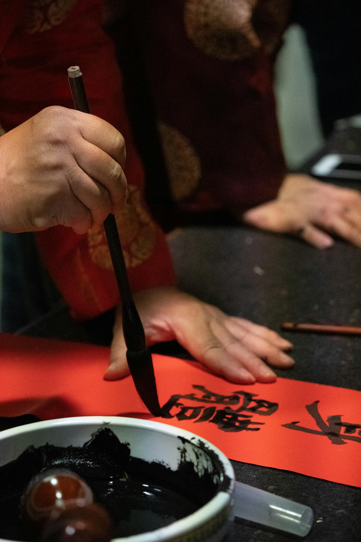 Men practicing Chinese calligraphy as a symbol of Cantonese language preservation