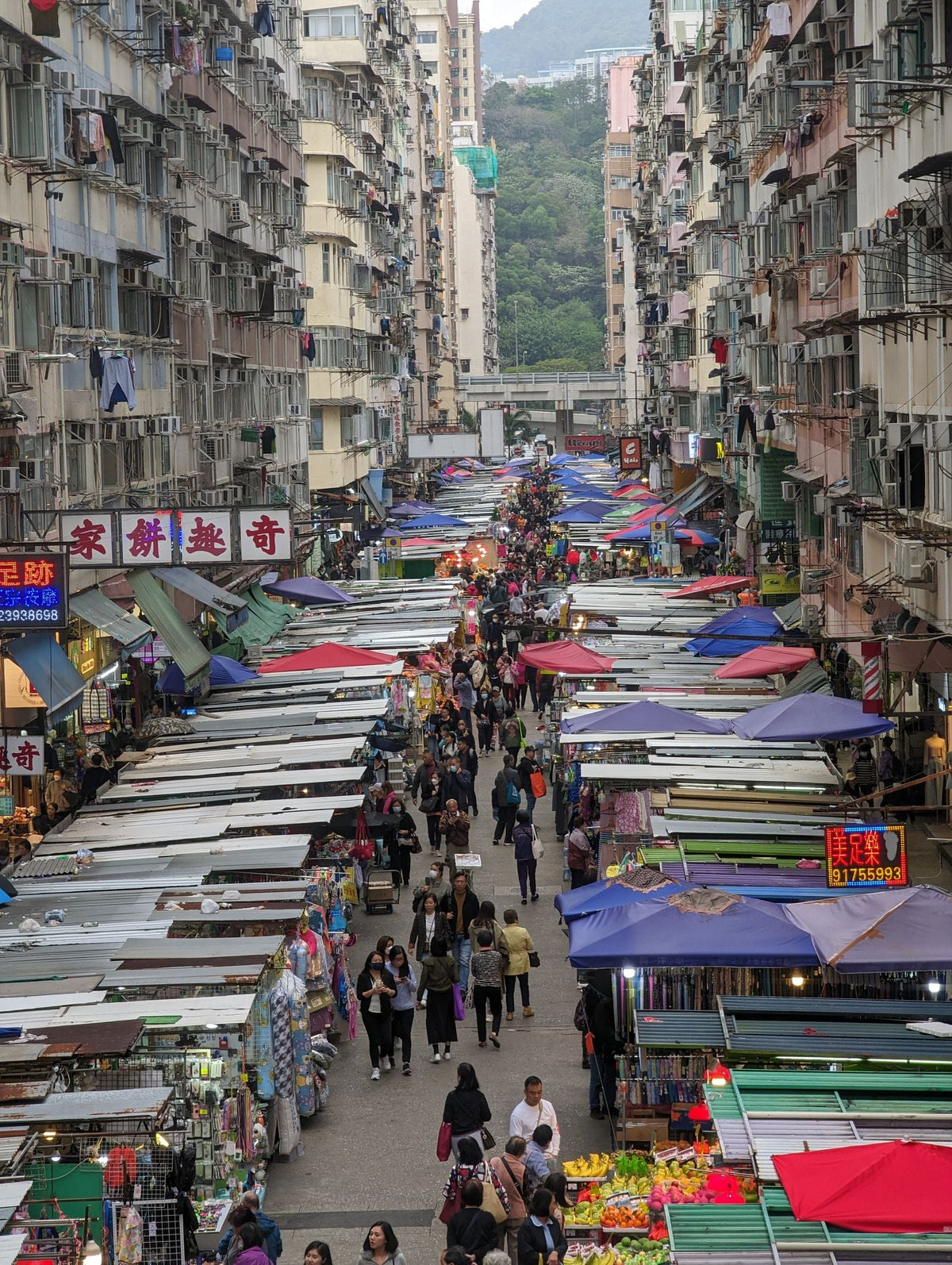 Hong Kong wet market street stall at dusk with vendors and produce