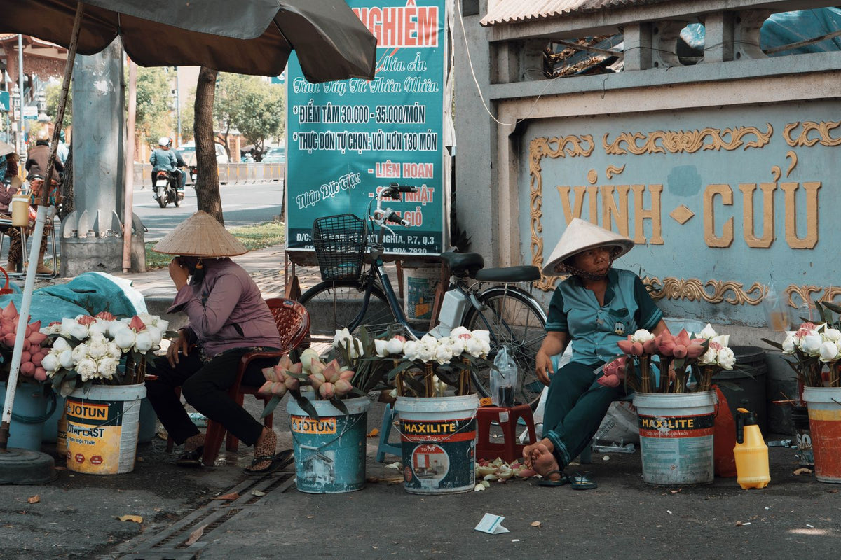 Urban street market with flower vendors and buckets of fresh blooms