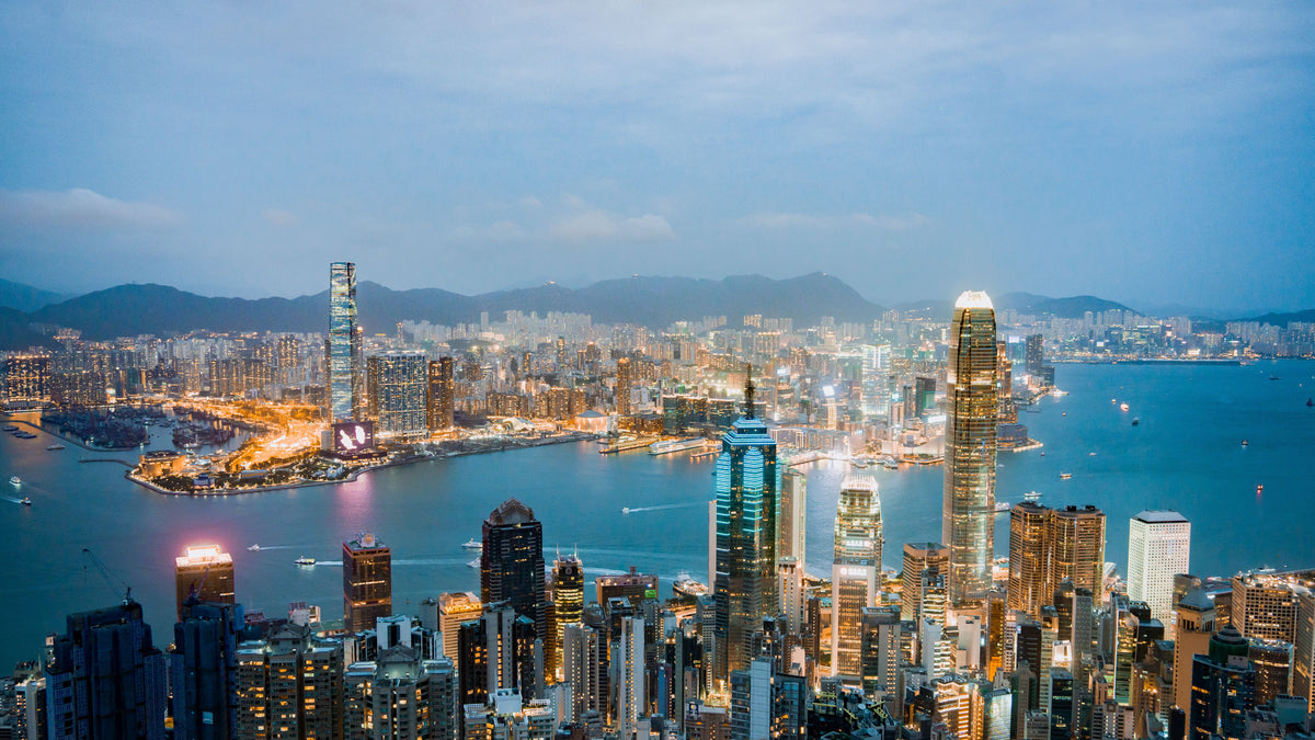 Evening panorama of Victoria Harbour in Hong Kong with illuminated skyscrapers on both shores