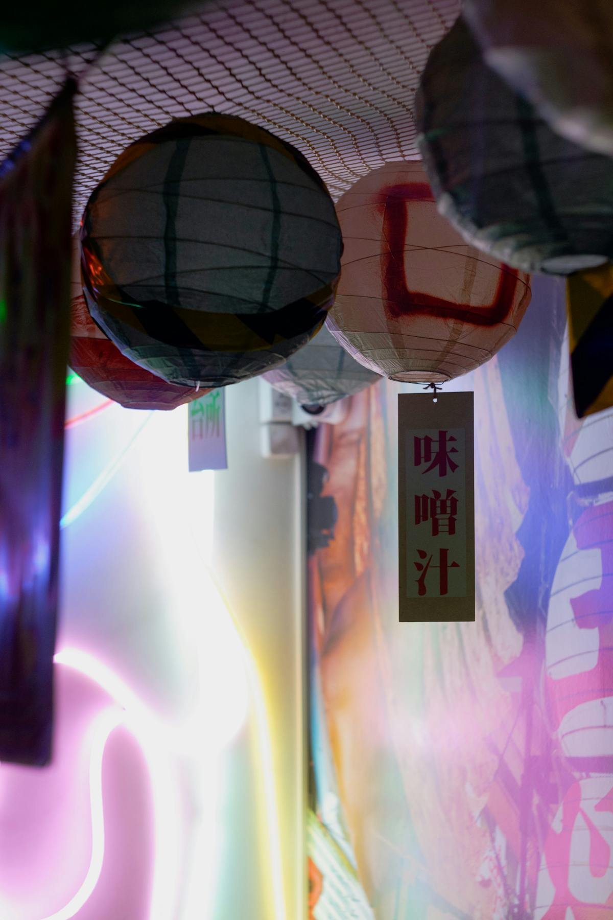 Colorful traditional Chinese lanterns glowing warmly against a dark background