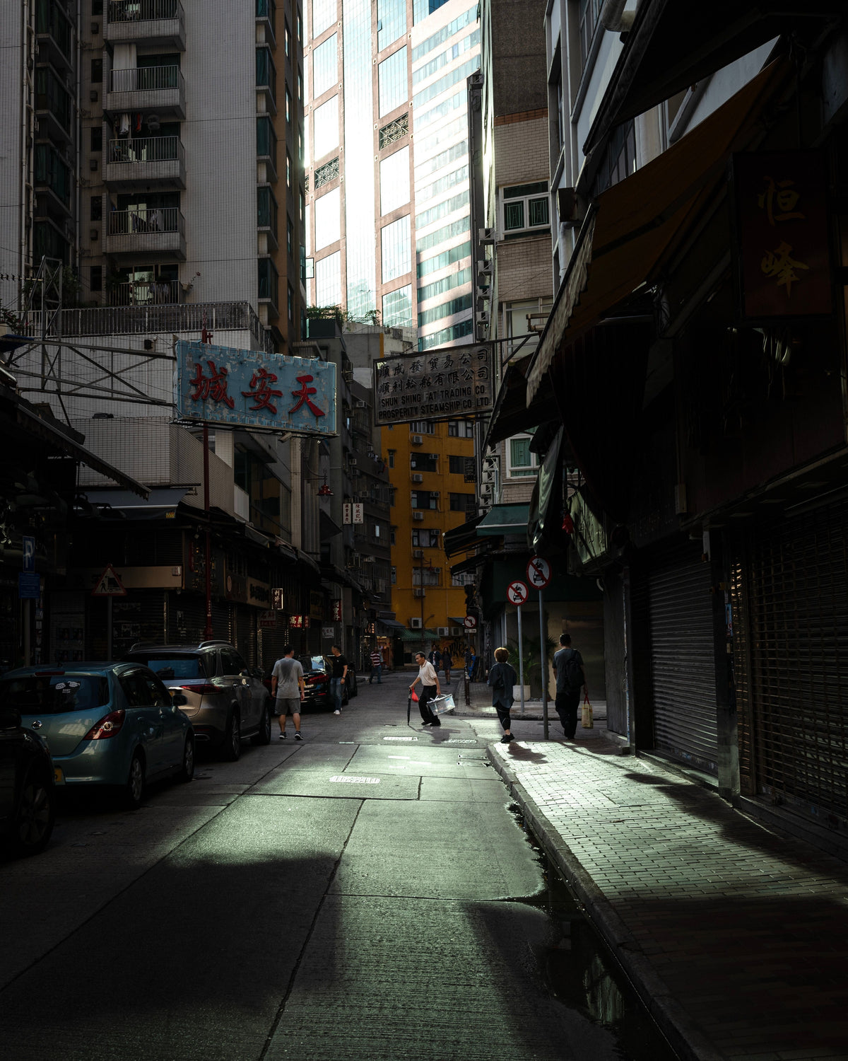 Moody Hong Kong urban street at dusk with high-rise buildings and pedestrians