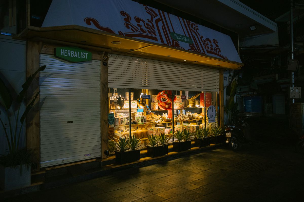 Nighttime view of a traditional Chinese herbalist shopfront lit from within