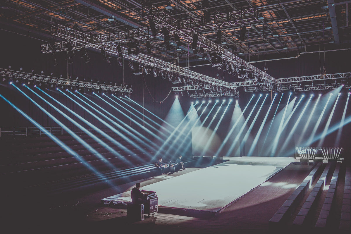 An expansive indoor stage with a dramatic warm lighting setup, ready for a performance