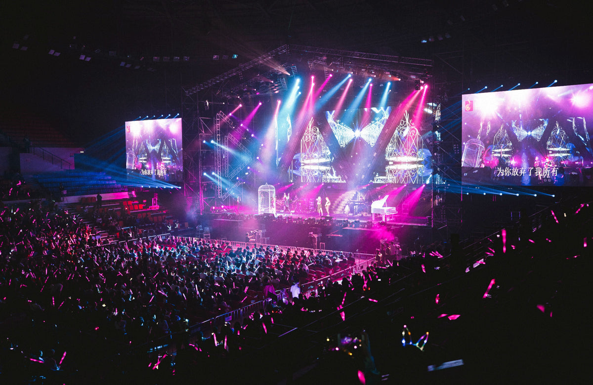 Colorful live concert stage with vibrant lighting — the era Aaron Kwok's Four Heavenly Kings run defined