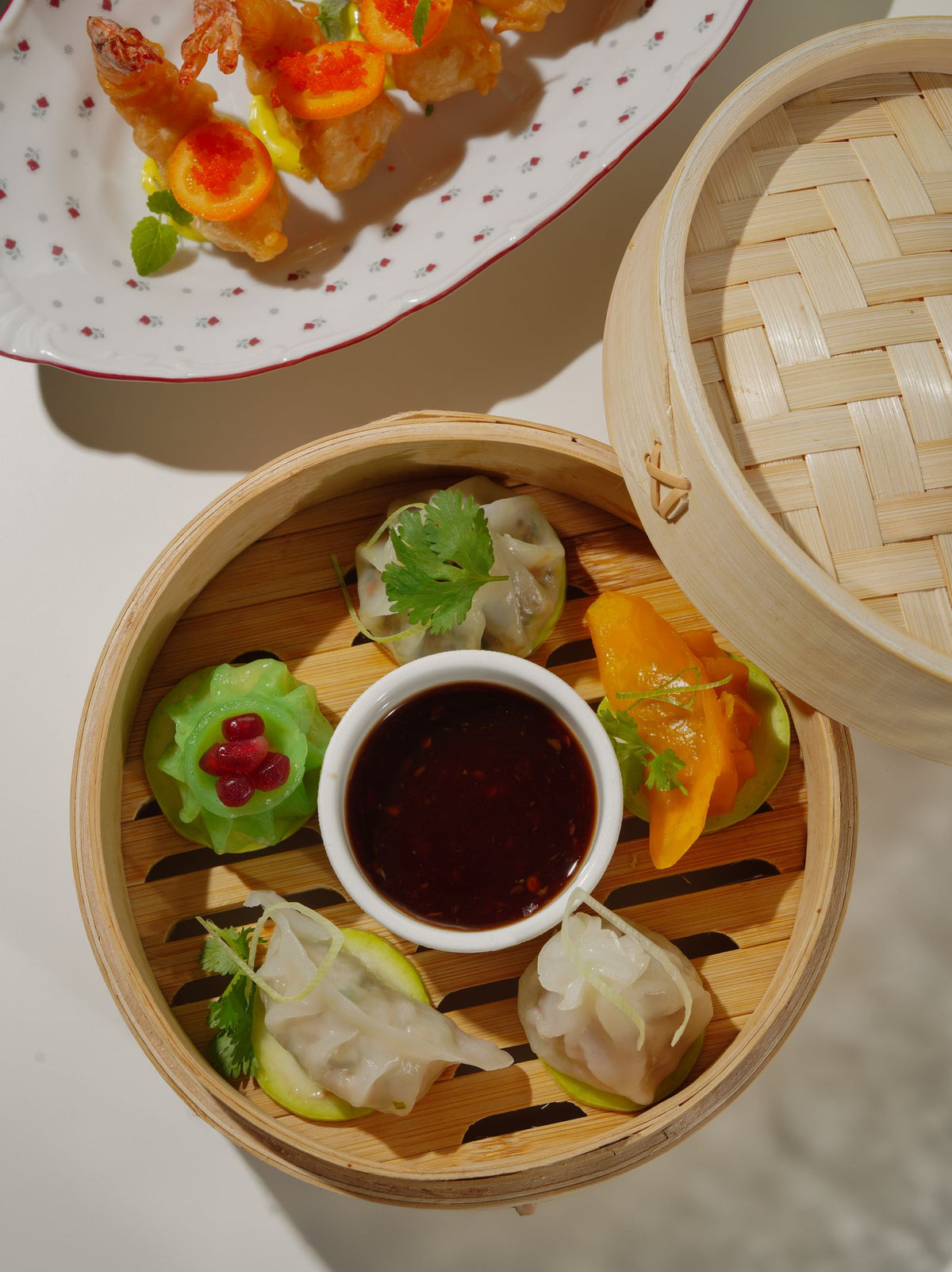 A vibrant Cantonese dim sum spread served in bamboo steamers with soy dipping sauce including cheung fun