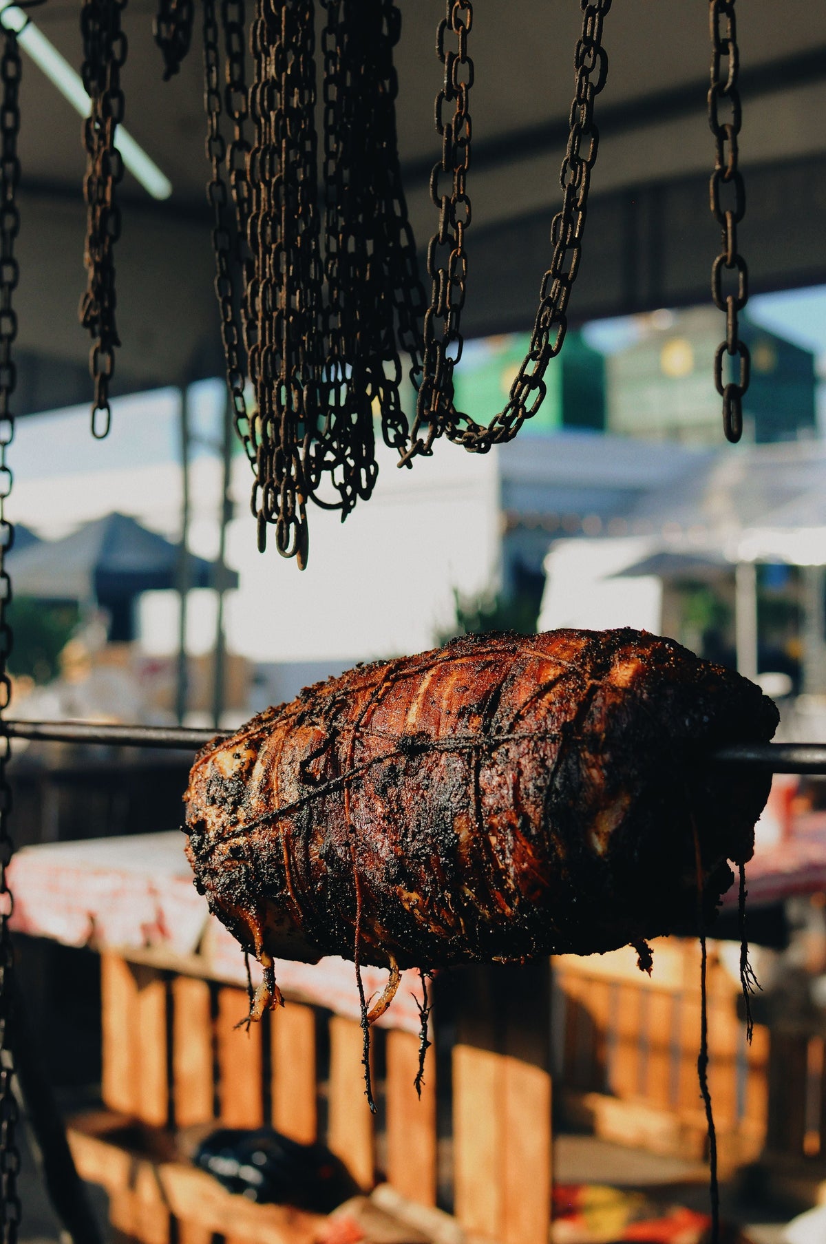 Cantonese roast pork hanging on chains at a siu mei shop
