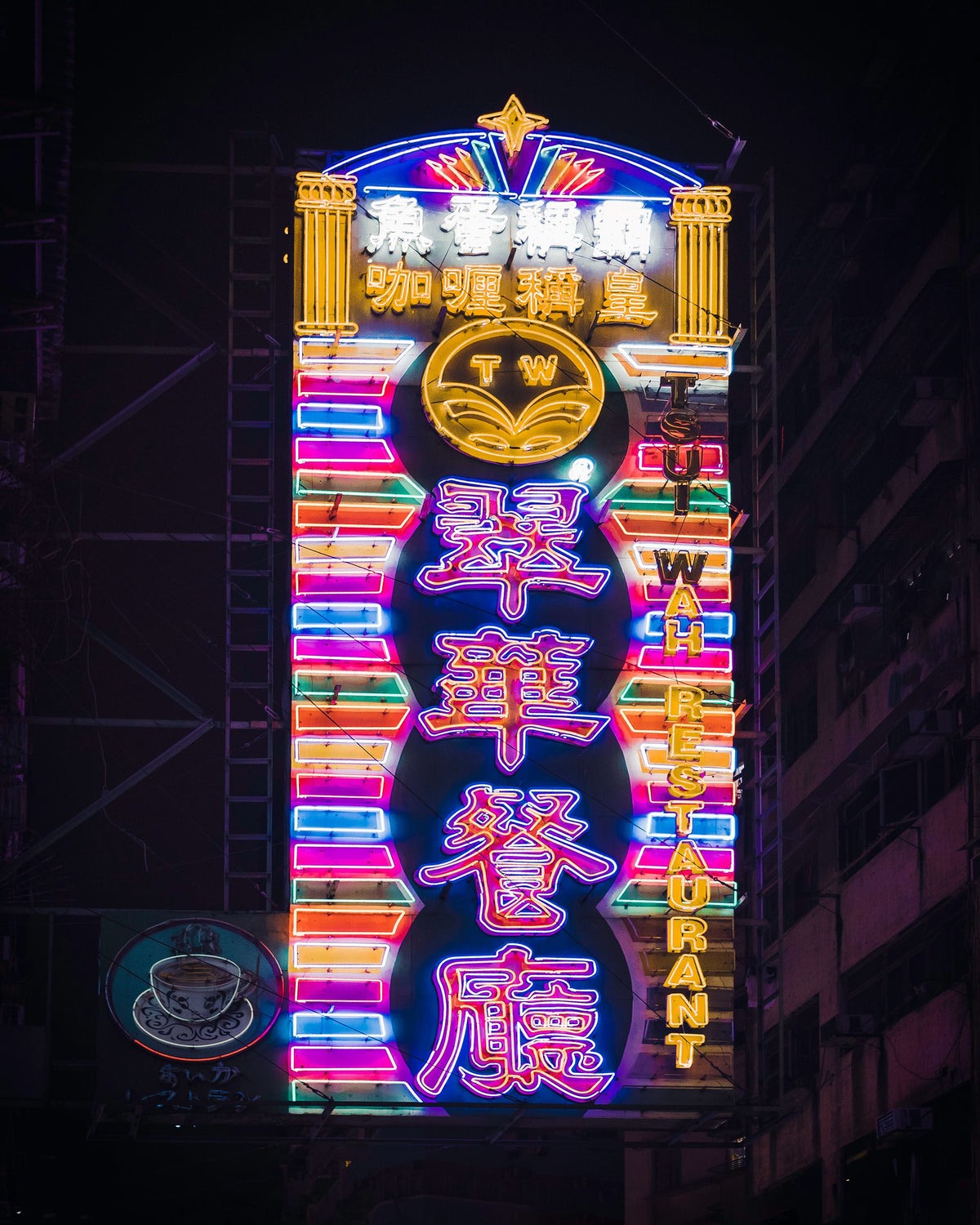 Glowing neon sign of a Hong Kong cha chaan teng at night with pedestrians passing on the street