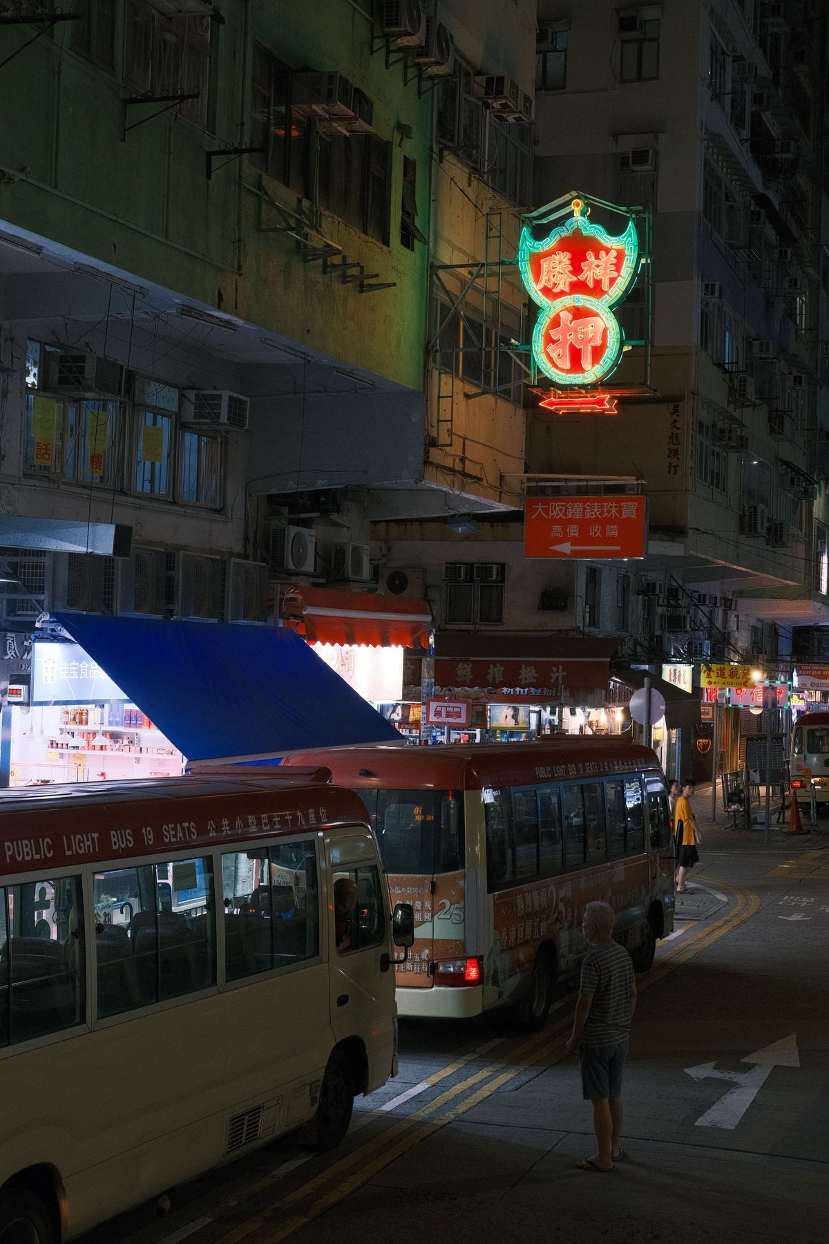 Nighttime Hong Kong urban scene with buses and glowing neon signs