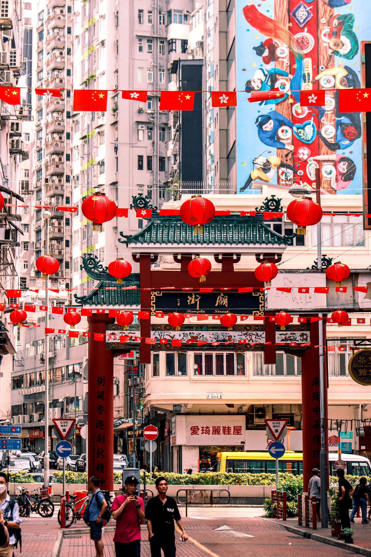 Busy Kowloon Hong Kong street at night with red lanterns strung above and crowds walking under them