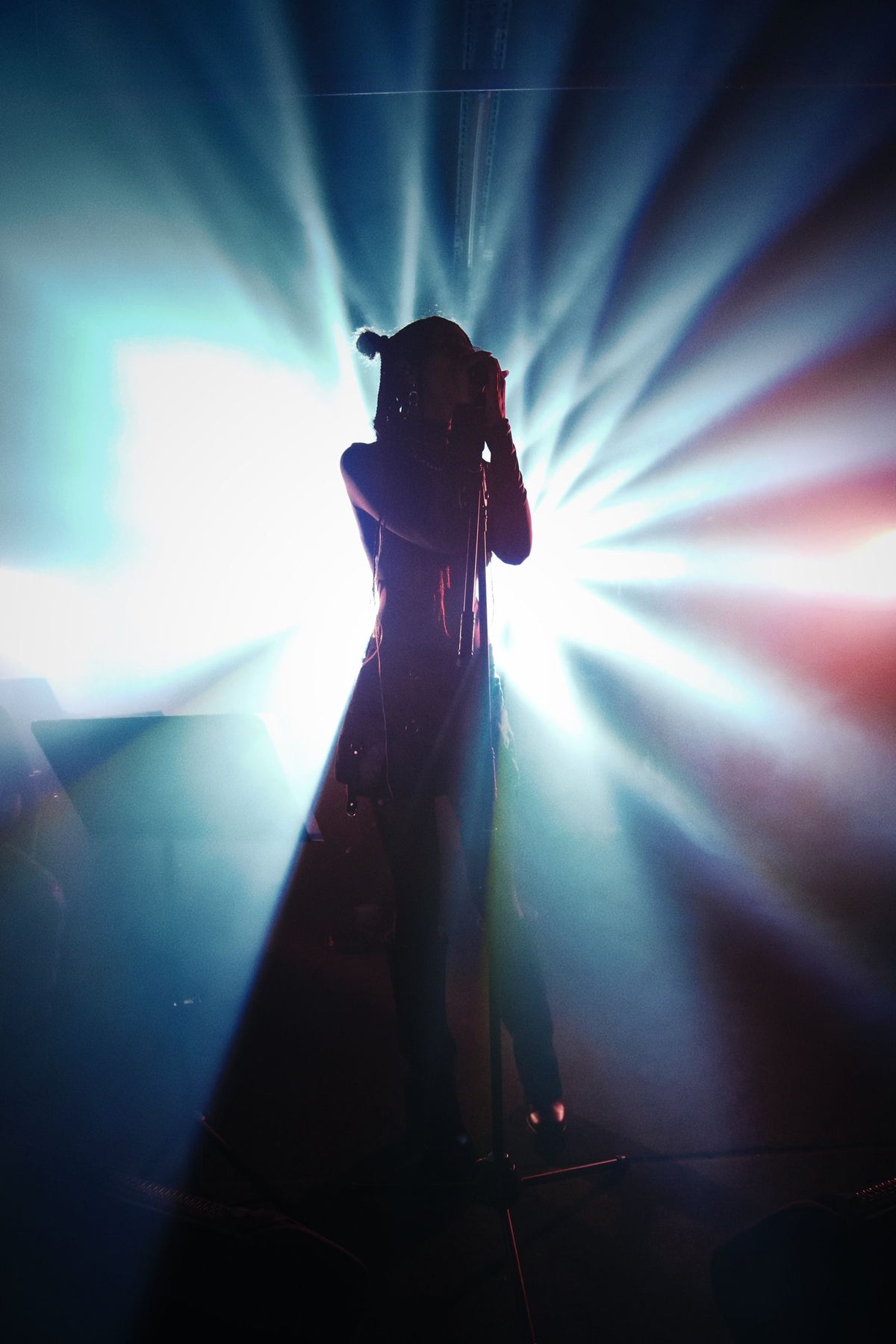 Dramatic silhouette of a concert singer in a spotlight with vibrant stage lighting