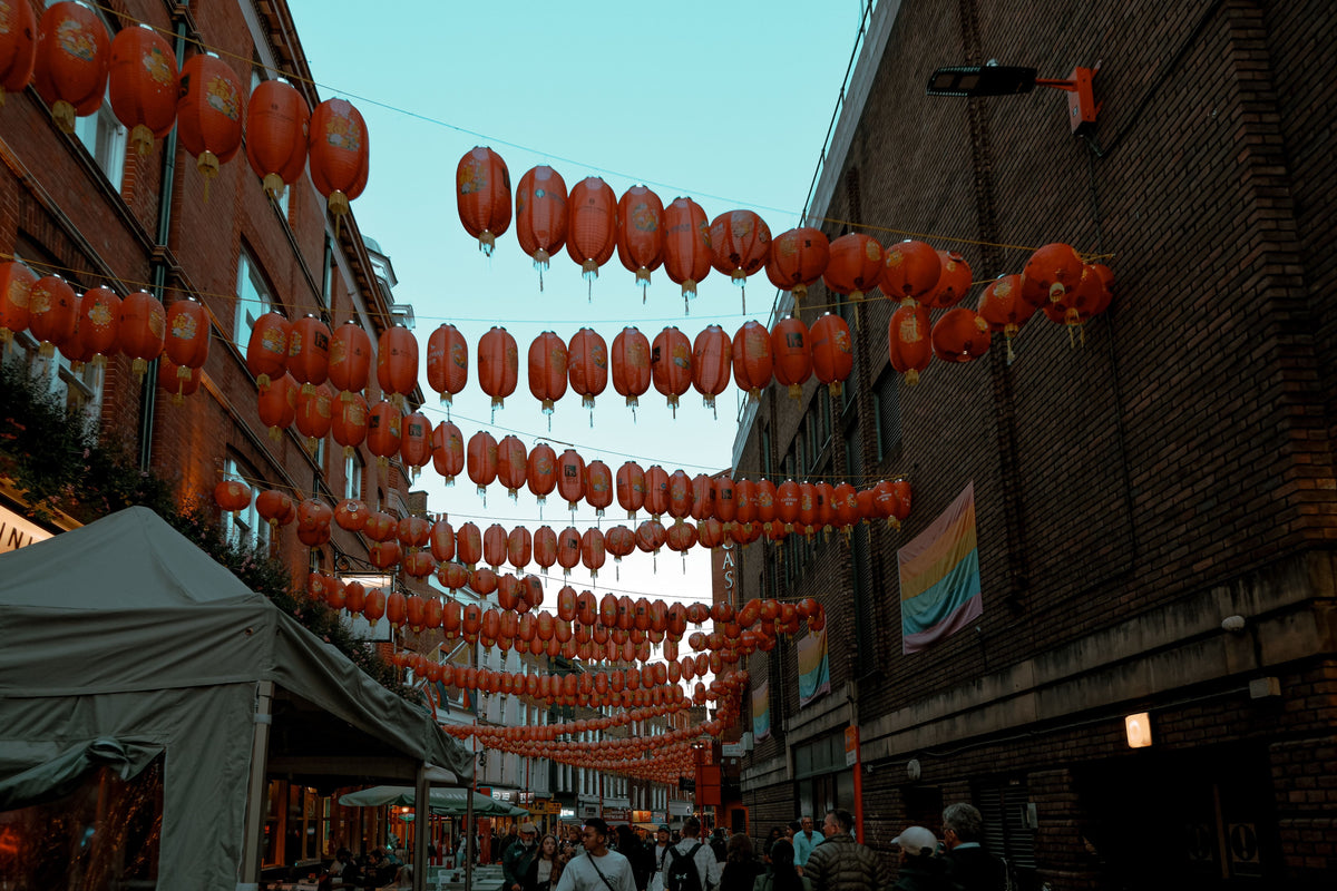 Red lanterns glowing above London Chinatown at twilight