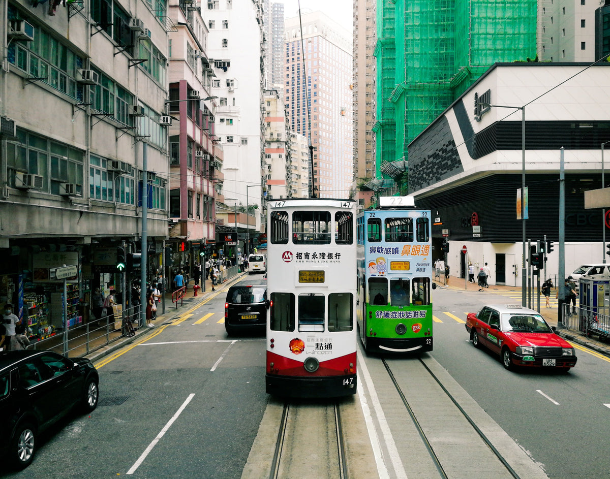 Double-decker trams on a bustling Hong Kong street