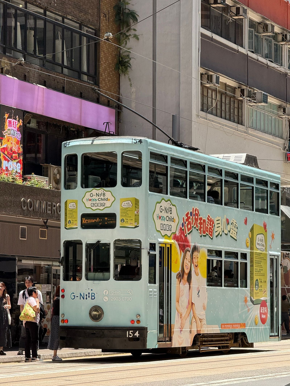 Vintage double-decker Hong Kong tram on a busy island street evoking 1970s Hong Kong atmosphere