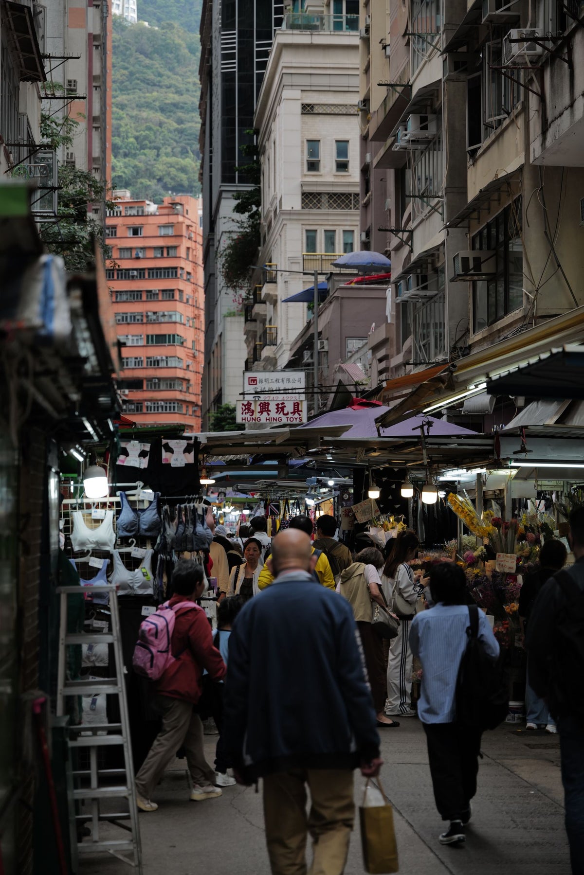 Vibrant Hong Kong street market scene with people in a dense urban setting