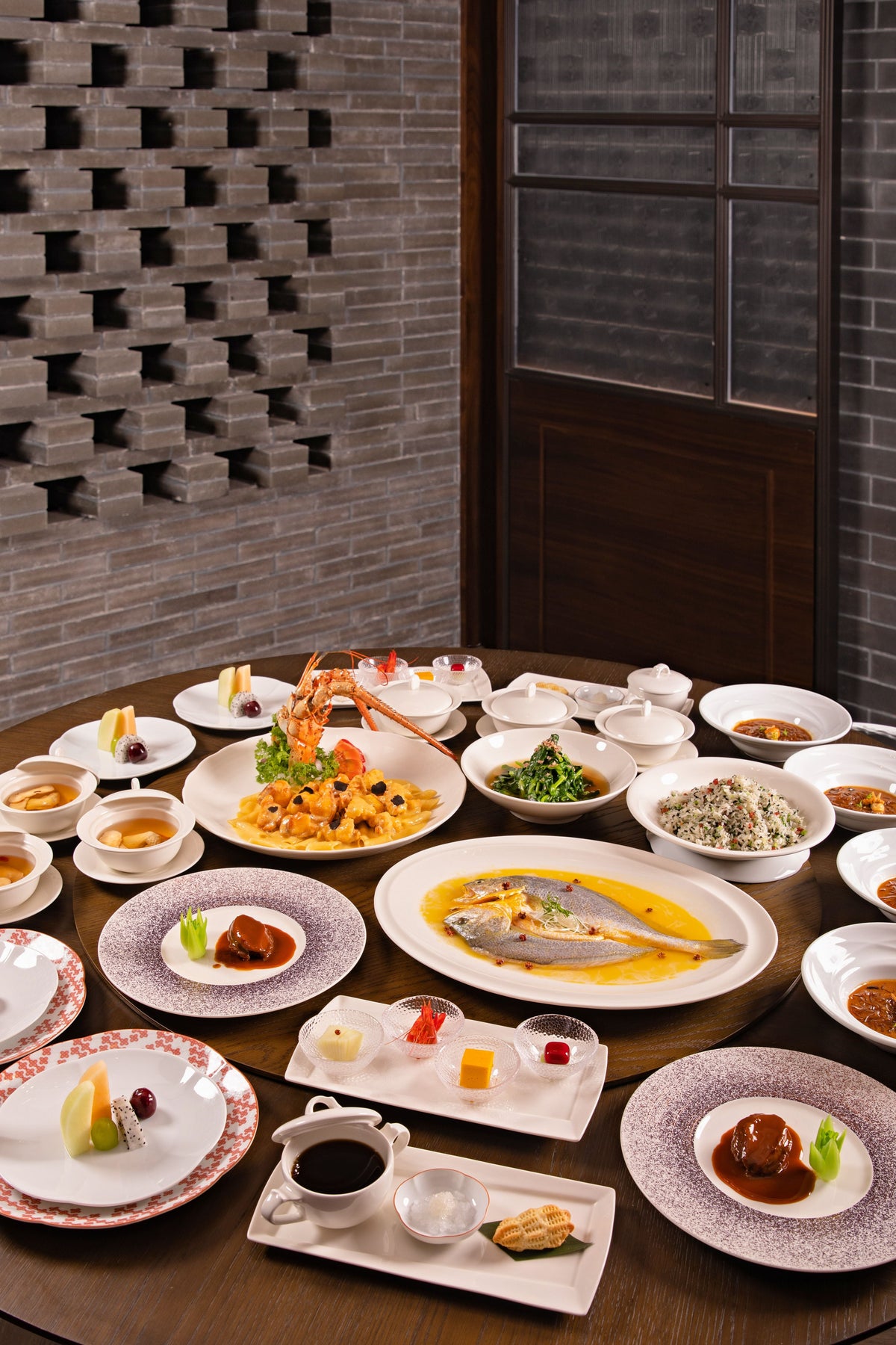 Chinese banquet featuring a wide array of traditional dishes arranged on a large round table — a poon choi-style spread