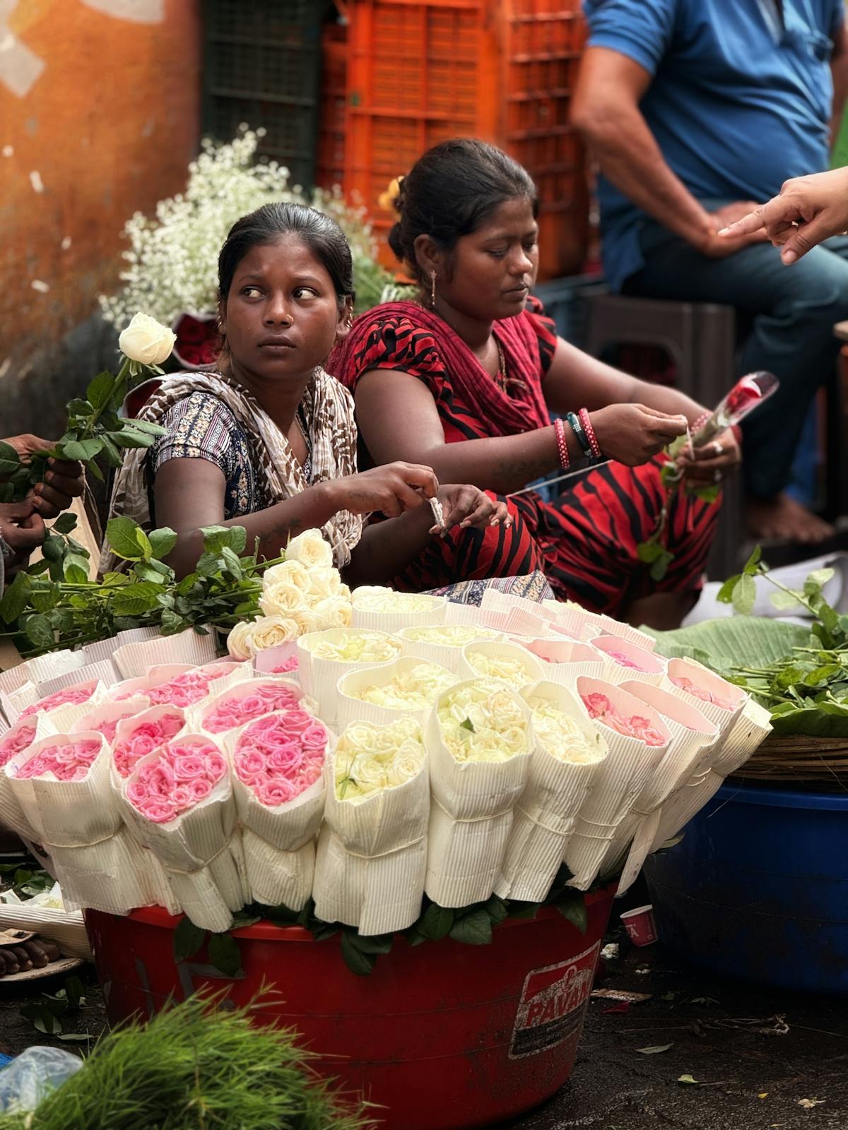 Vibrant flower market scene with vendors selling colourful roses and blooms