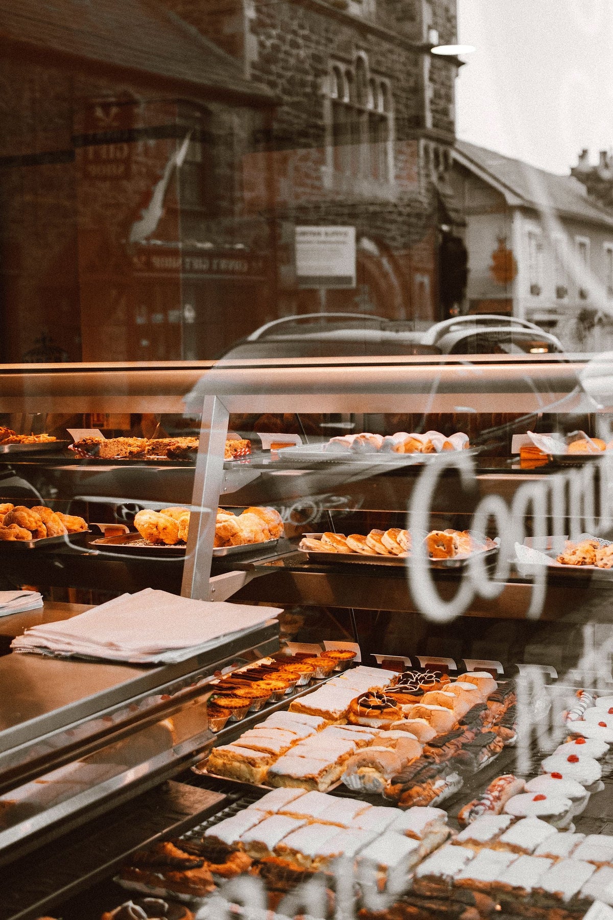 Freshly baked golden bread and pastries lined up on trays in a bustling cha chaan teng bakery