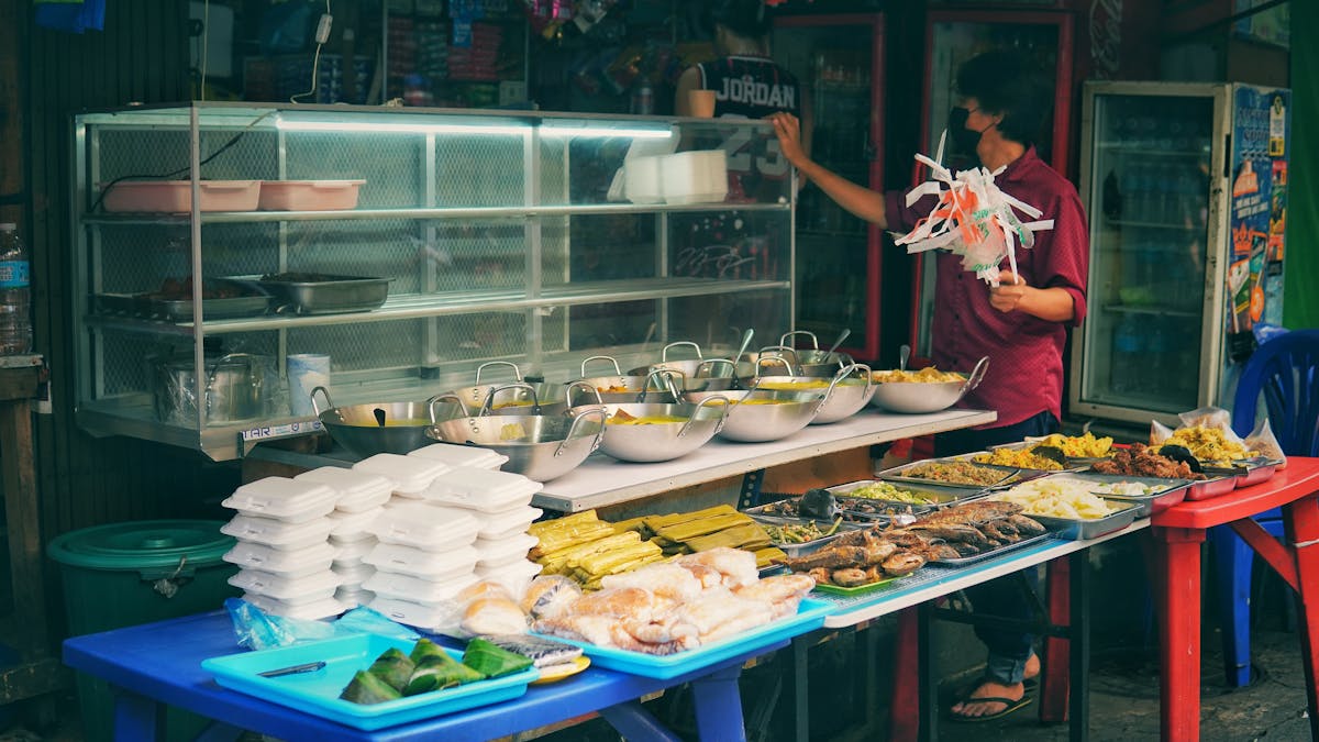 Street food vendor stall in Asia with various traditional dishes on display