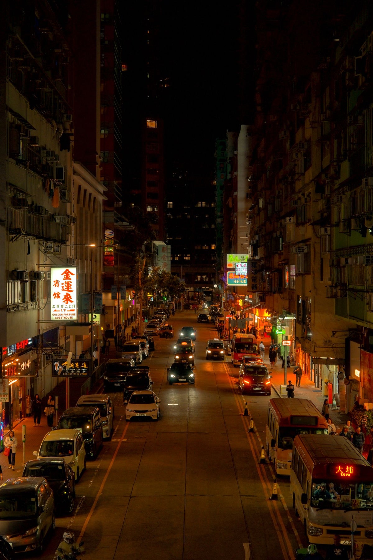 Bustling night street in Kowloon, Hong Kong with neon signs