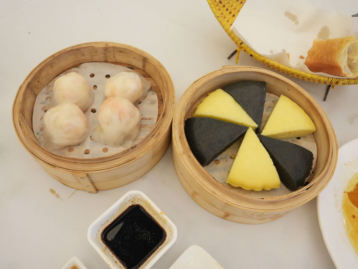 Assorted dim sum dumplings stacked in traditional bamboo steamers