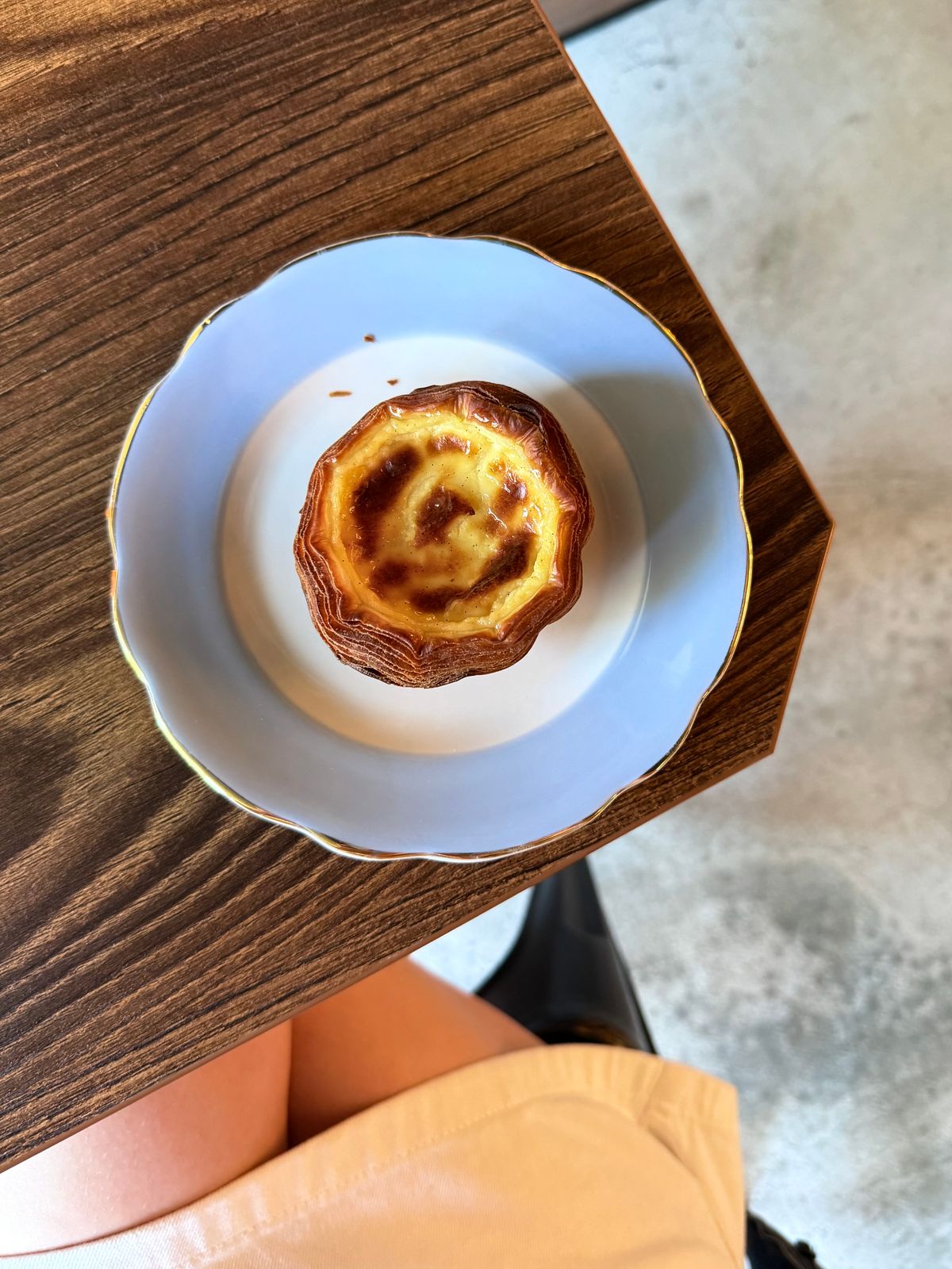 A perfectly baked custard tart on a plate — the ancestor of Hong Kong's egg tart