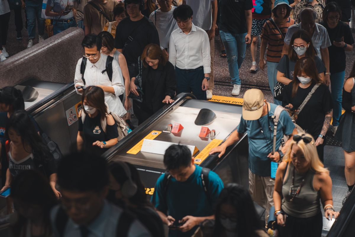 Busy Hong Kong MTR subway station crowd on escalators