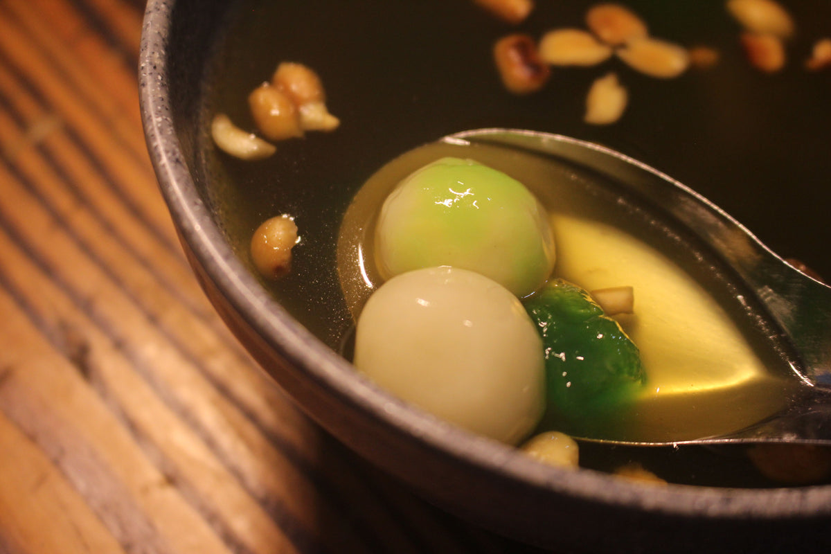 Traditional Chinese tangyuan sweet dessert served in a bowl with nuts and seeds