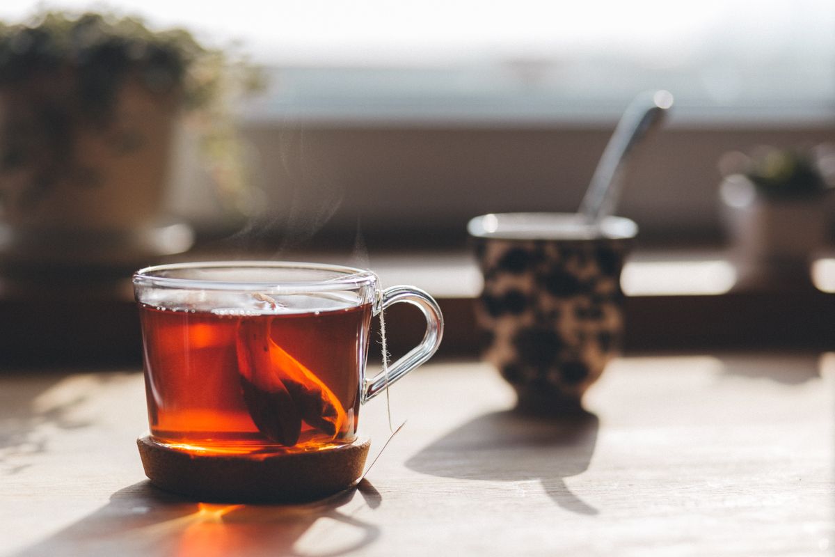 A steaming cup of tea on a wooden table