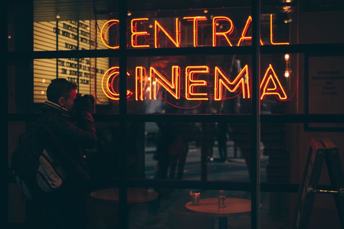 A glowing orange cinema LED signage at night