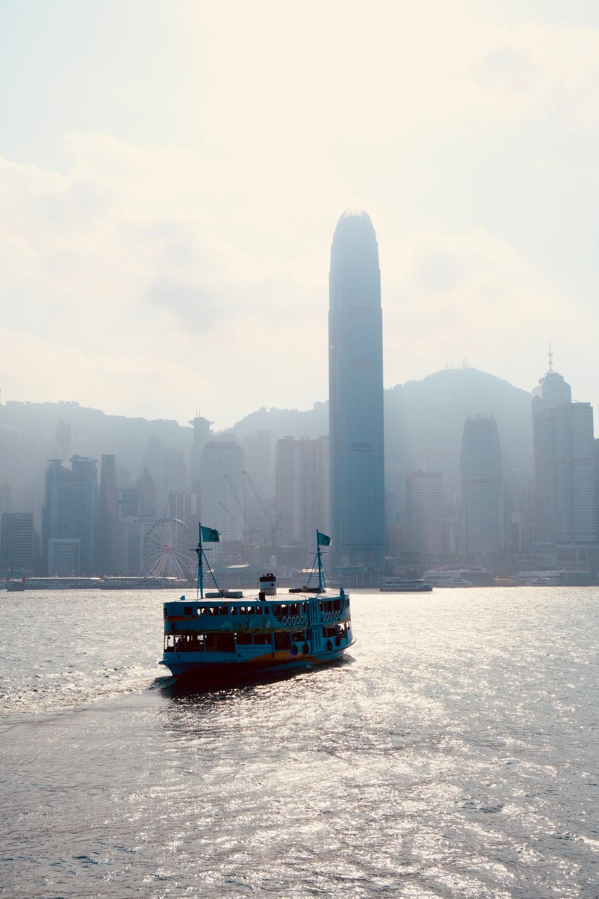 Star Ferry silhouetted crossing Victoria Harbour at sunrise with Hong Kong skyline