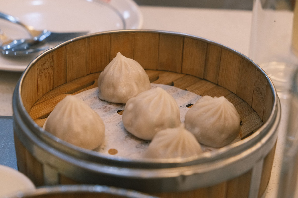 Steamed dumplings in a traditional bamboo basket — the same universe lo mai gai lives in at a Cantonese yum cha hall