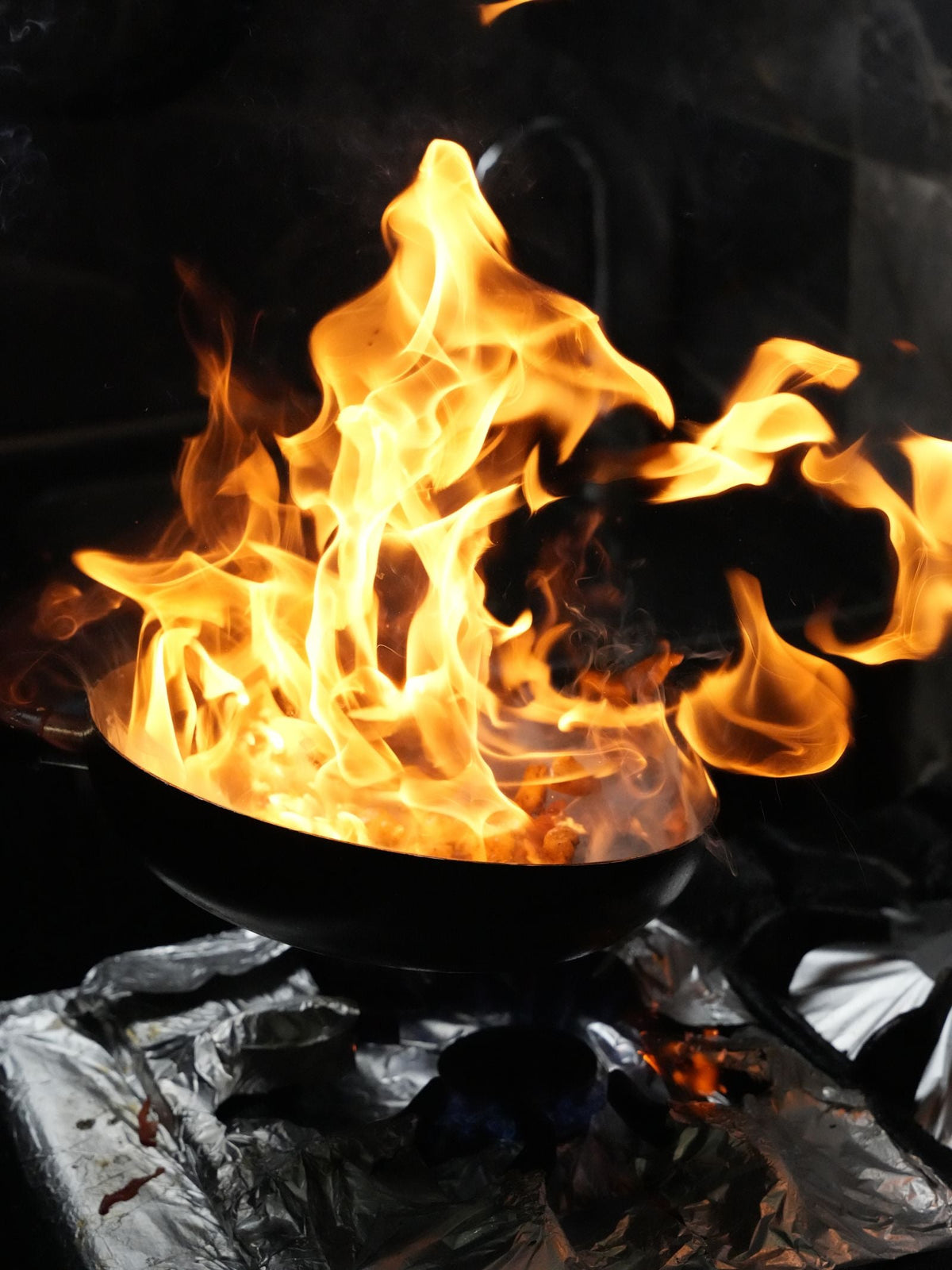 Dramatic flames leaping from a wok during stir-frying
