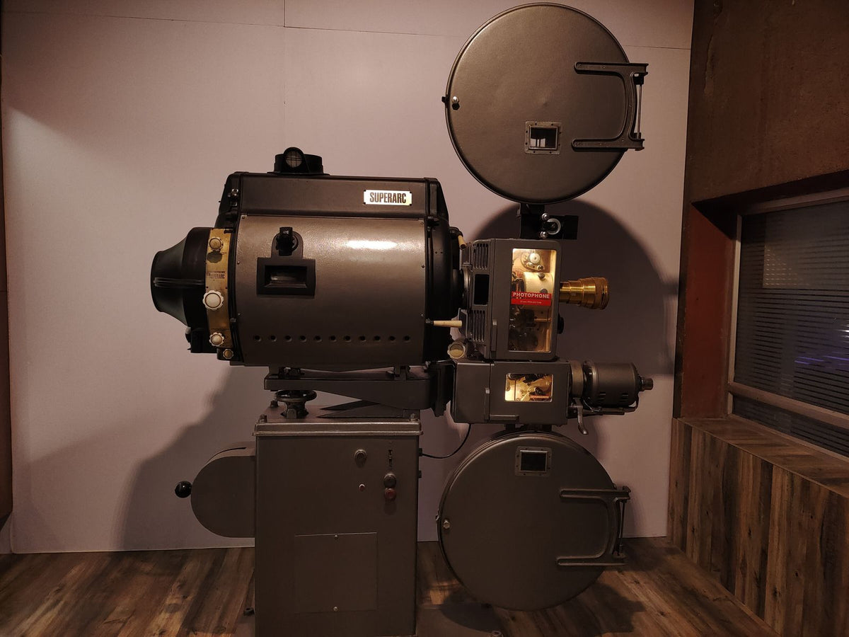 Vintage movie projector in a dimly lit cinema projection room