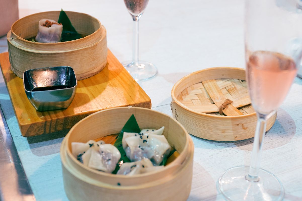 Traditional Cantonese dim sum in bamboo steamers on a wooden board
