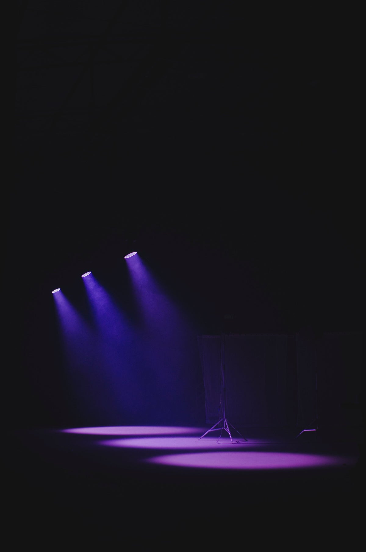 Moody concert stage with purple spotlights casting a vivid glow — the 1990s Cantopop era Aaron Kwok defined