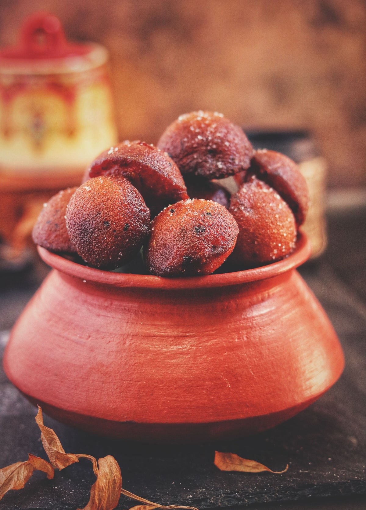A rustic clay pot filled with steaming hot food set on a wooden surface