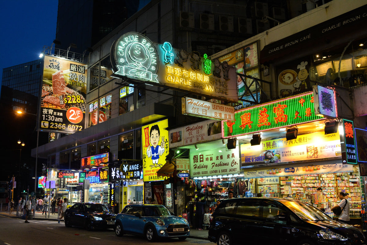 Traditional Hong Kong shopfront exterior with red signboard and layered neon signs on an old street at night, representing the historic Cantonese pawn shop aesthetic
