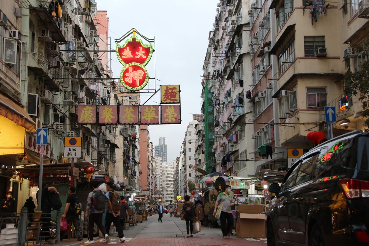 A busy street in Hong Kong showing shops and vendors
