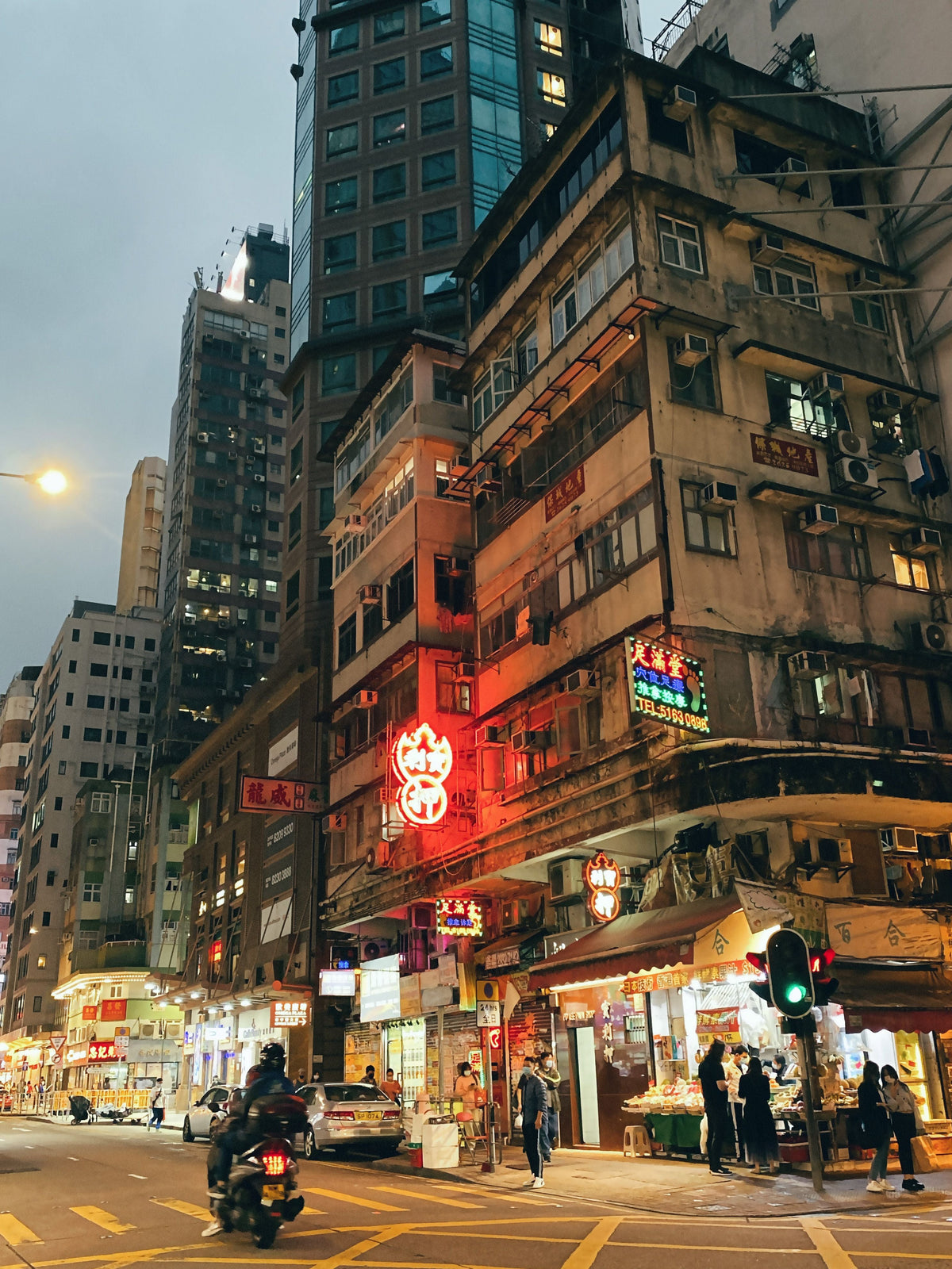 Bustling Hong Kong street at night with high-rise buildings and glowing neon signs