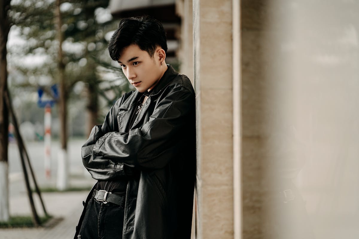 Stylish young Asian man standing confidently on a street