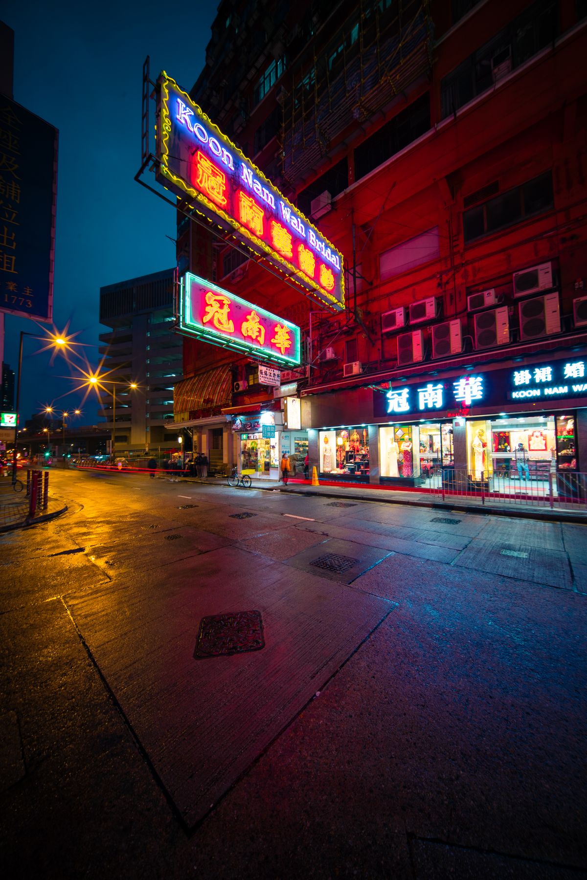Hong Kong street at night with layered neon signs projecting over the road