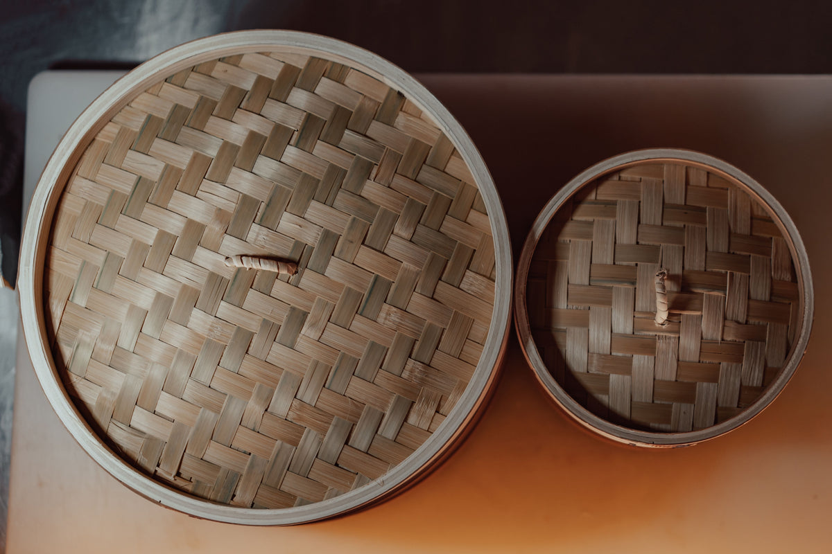 Overhead view of stacked bamboo dim sum steamers with woven pattern